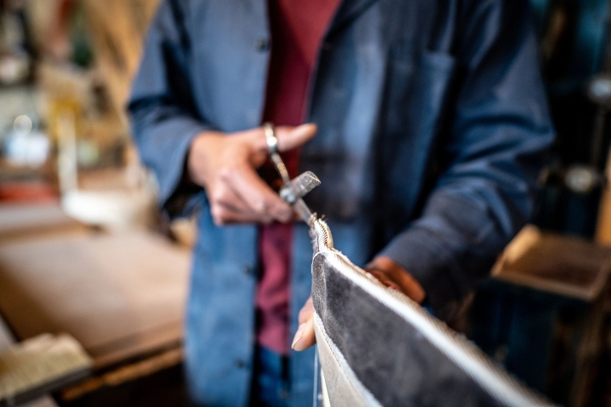 Craftsman cutting upholstery fabric in a workshop