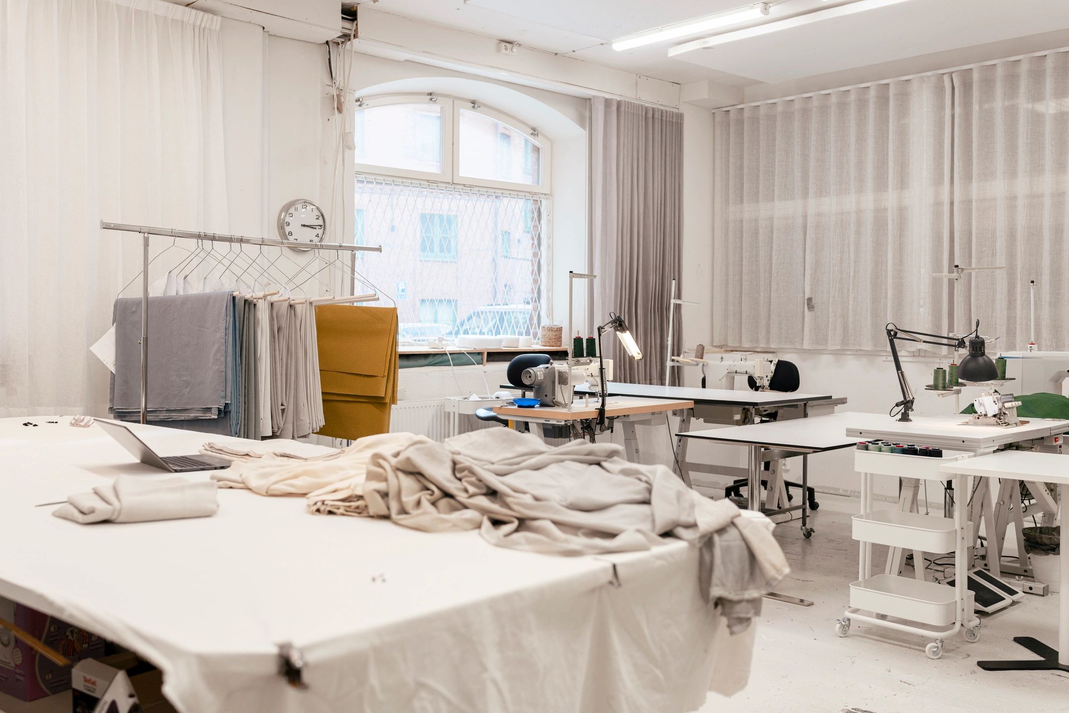 Bright upholstery and fabric workshop with rolls of fabric and sewing stations