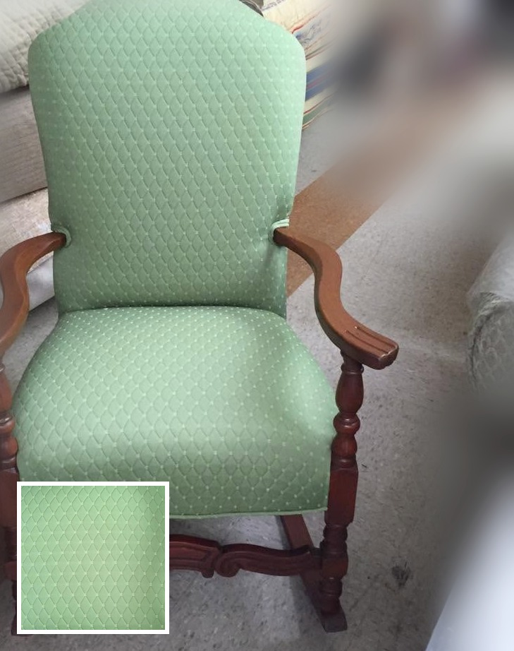 Green upholstered chair in a softly blurred room